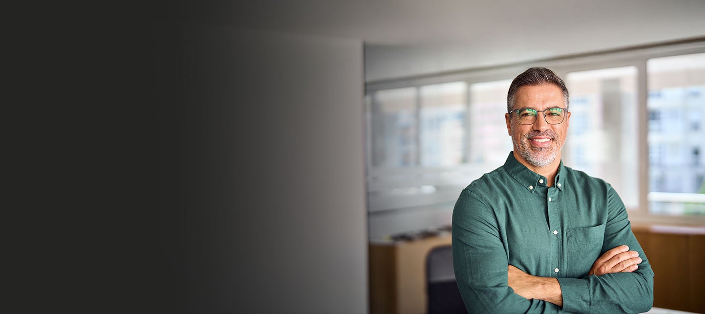 Confident small-business owner standing in a office.