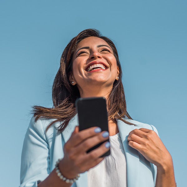 Woman smilying happyly using her phone