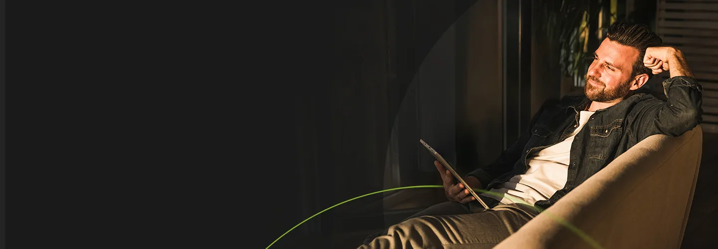 Man sitting in a chair looking at tablet