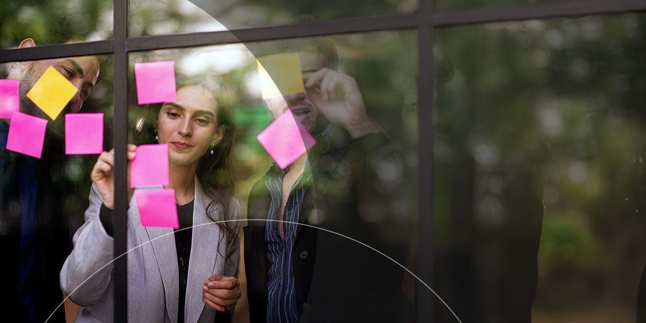 رجل وامرأة يضعان ملاحظات لاصقة على نافذة.