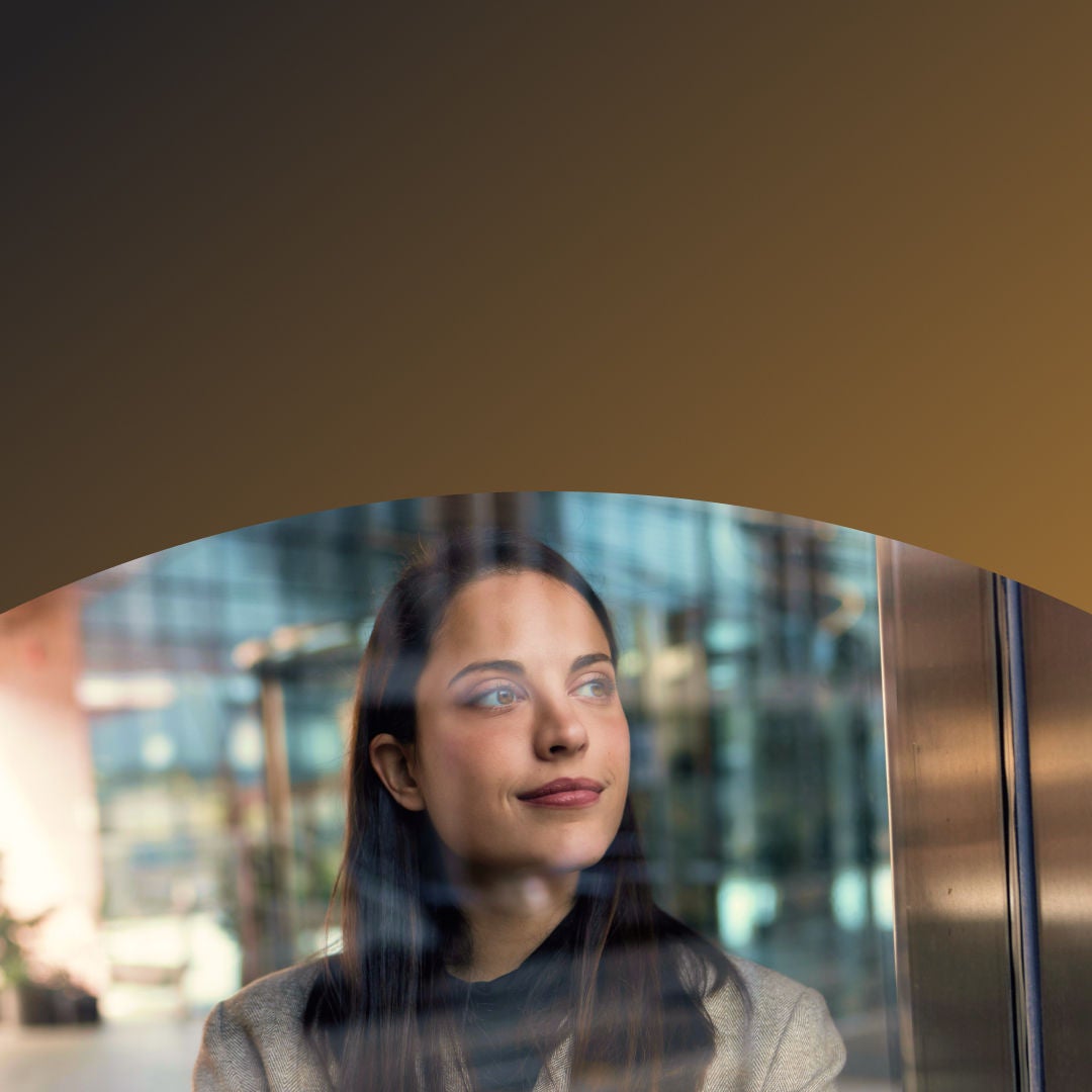 Woman looking at her reflection in an office window