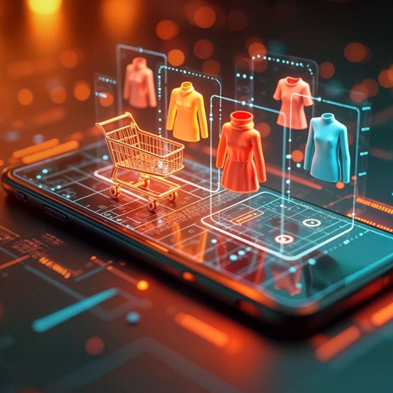 A smartphone with projections of a shopping card and women's clothes on top of it. 