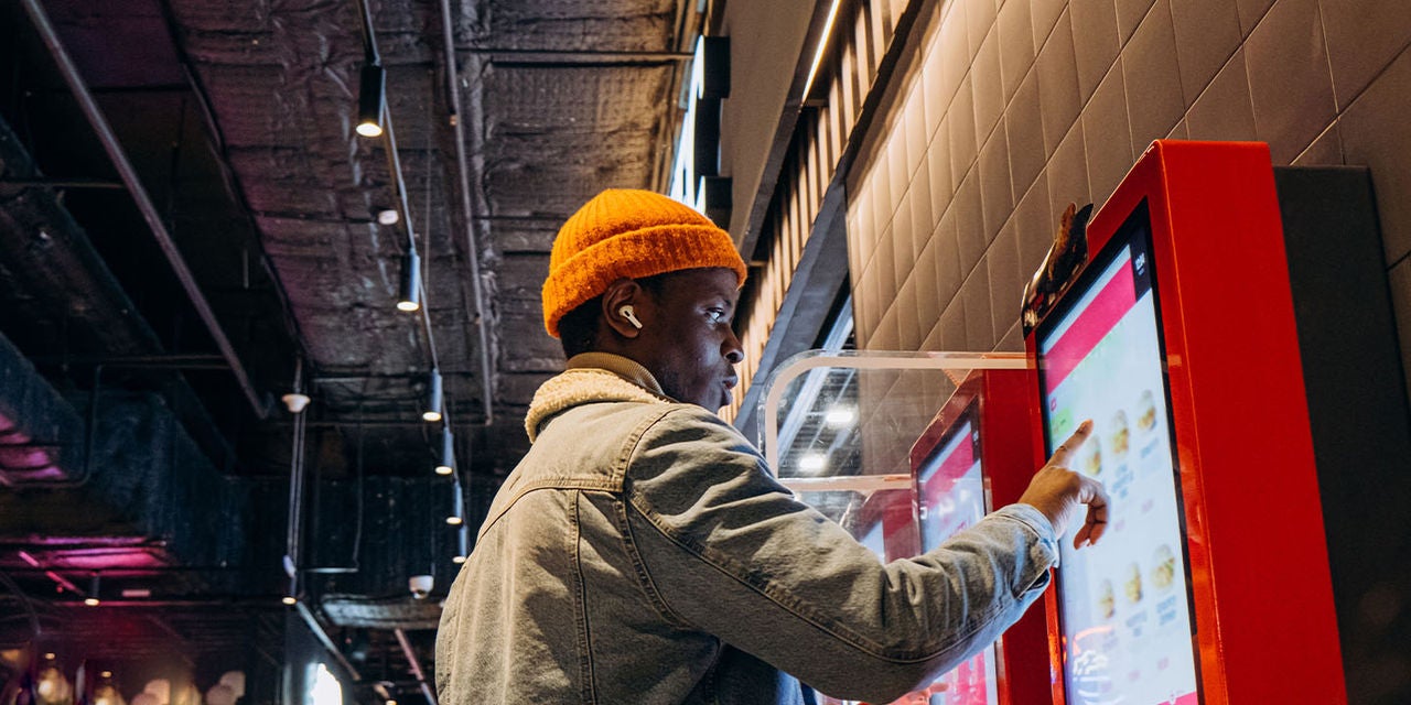 Man operating a digital food kiosk