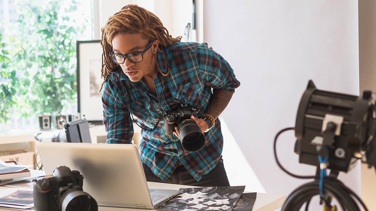 A photographer using laptop in studio.