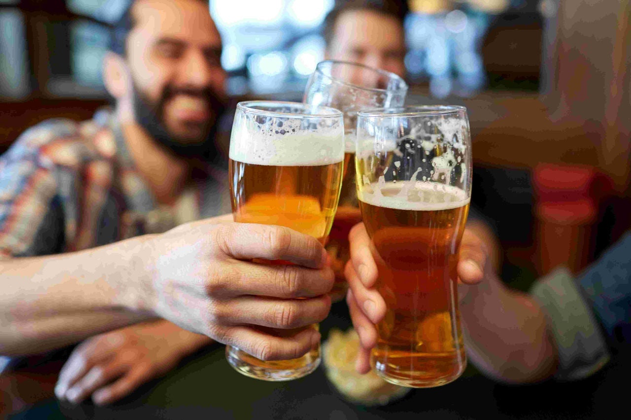 Friends toast one another with beer. 