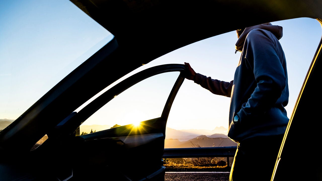 passeggero scende da auto in controluce
