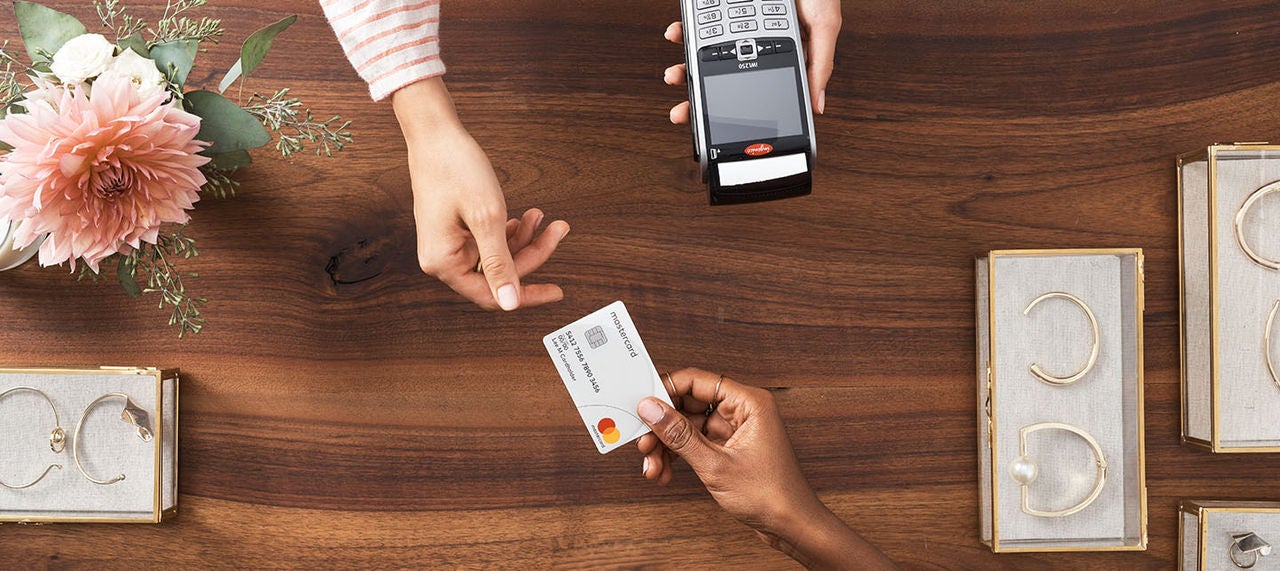 Customer making a payment with a Mastercard at a retail counter 