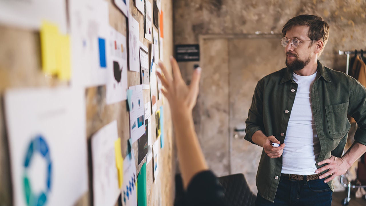 Man looking at insights on corkboard