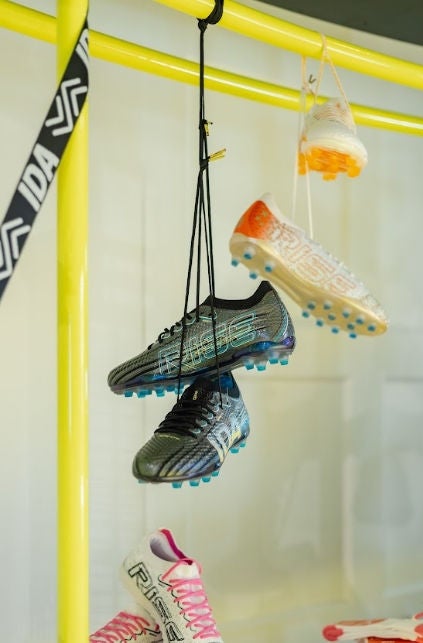 Adidași de femeie atârnă de un vitrin. 