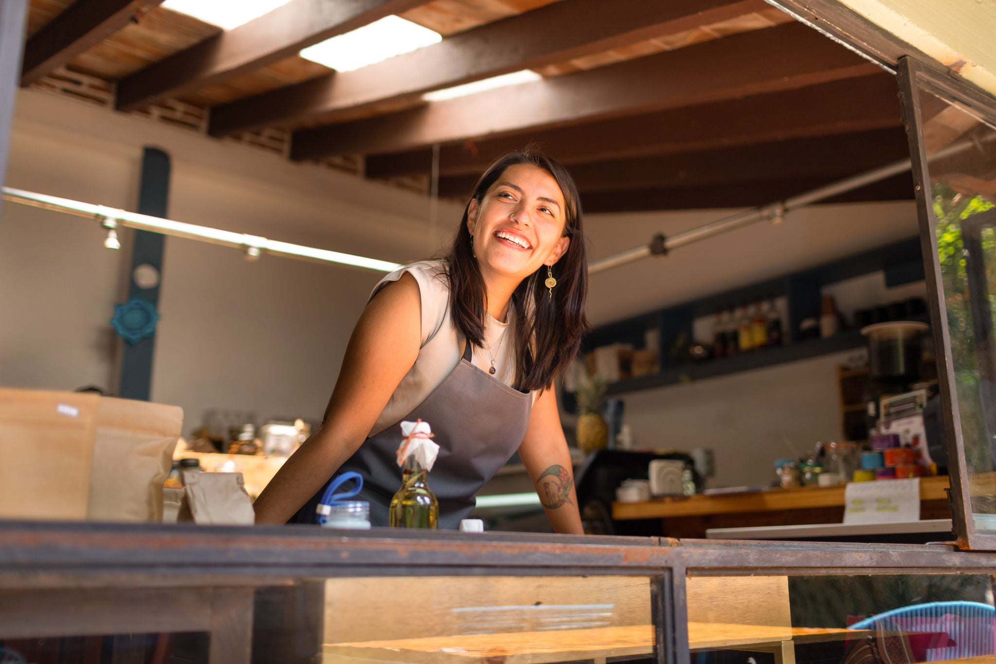 Woman smiling over the counter of her business