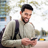 young smiling arab man using his phone.