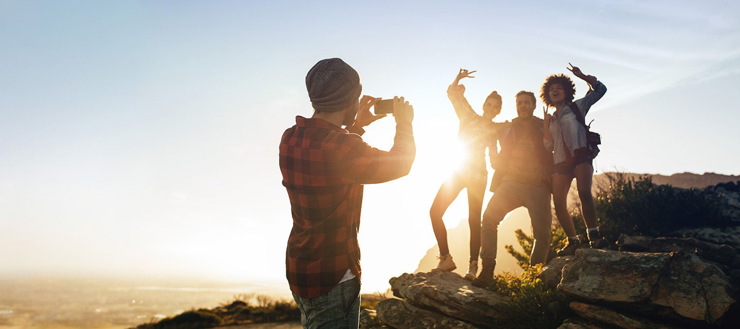 Man taking picture of friends on a mountain