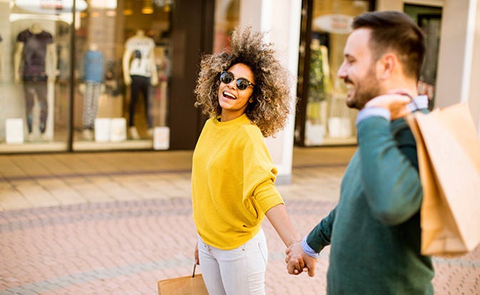 Hombre y mujer tomados de la mano mientras compran.