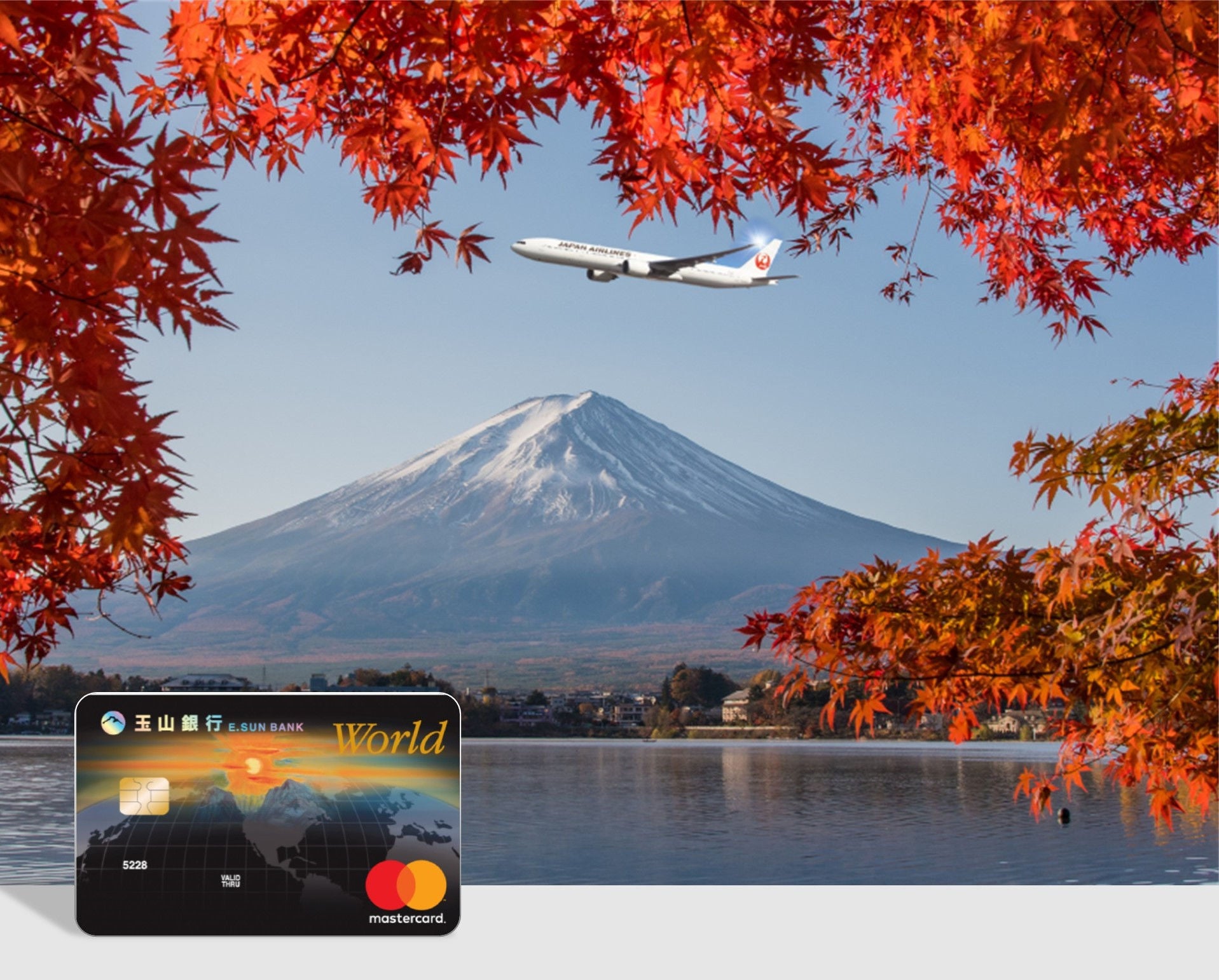 A snow-capped Mount Fuji seen across a lake framed by red autumn maple leaves, with a plane in the sky and a dark payment card in the lower left.
