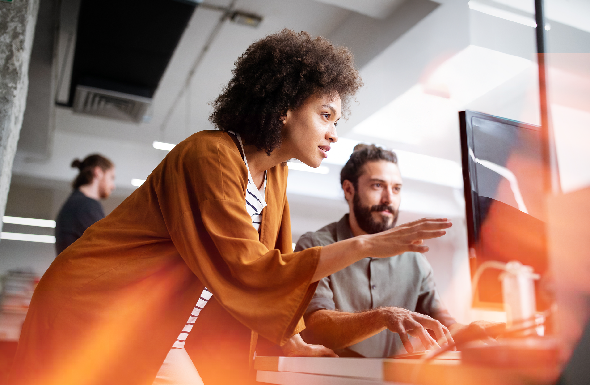 Woman and man brainstorming in front of a computer