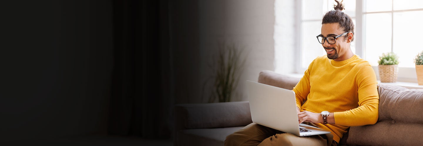 Man on his laptop at home on his couch