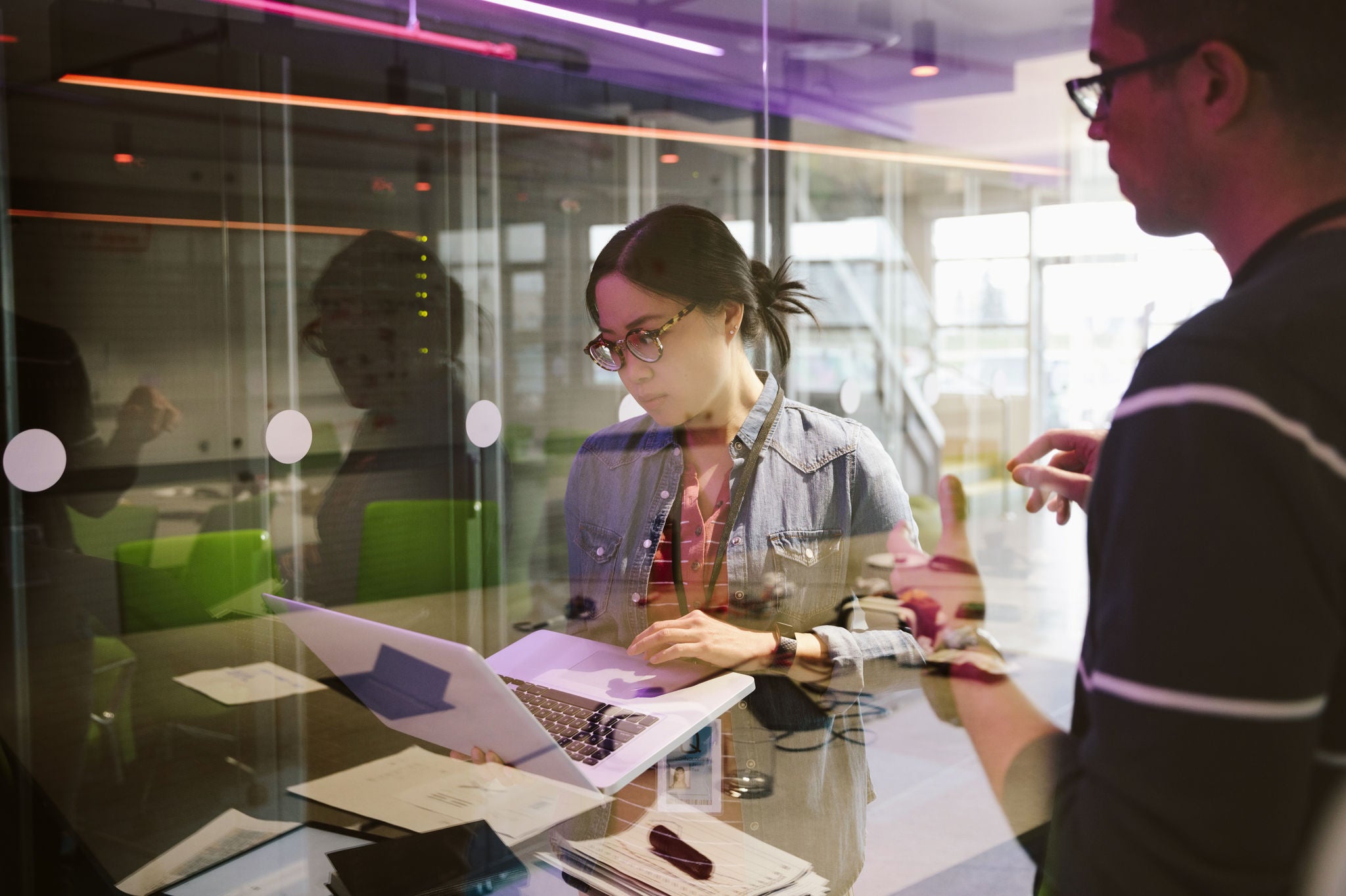 Woman looking at computer in a server room