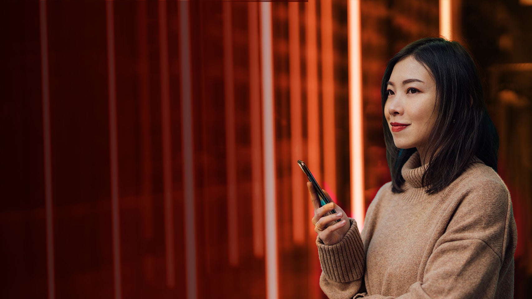 Woman holding a phone at night