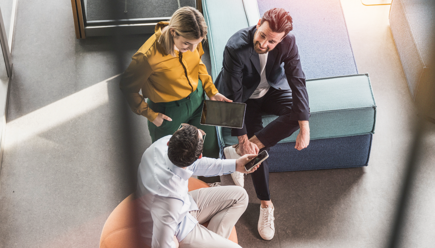 Three women brainstorming in front of a vision board