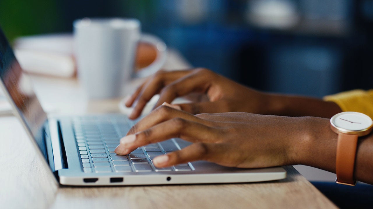 Female hands typing on a laptop.