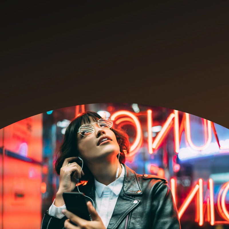 woman with earphones standing near neon signs