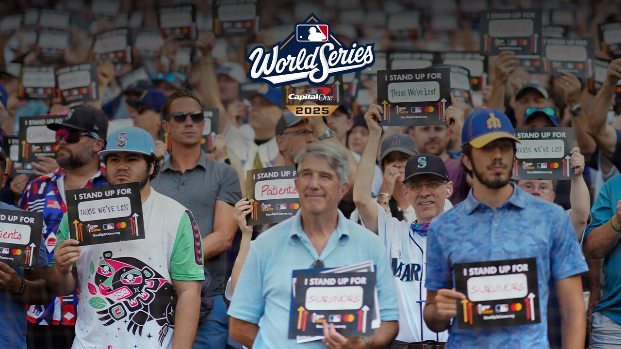 People standing with signs in support for SU2C at MLB event.