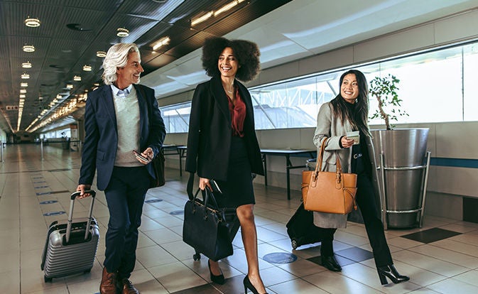 Business colleagues at airport with luggage.