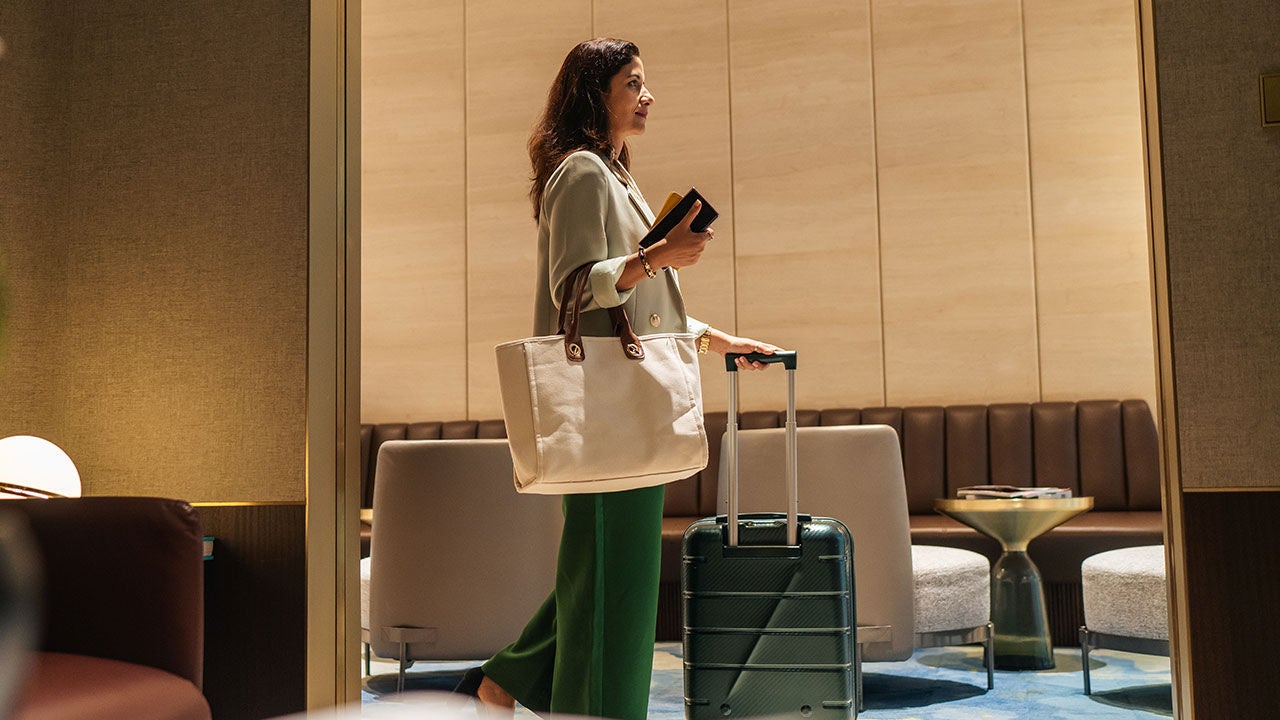 Woman with luggage in hotel.
