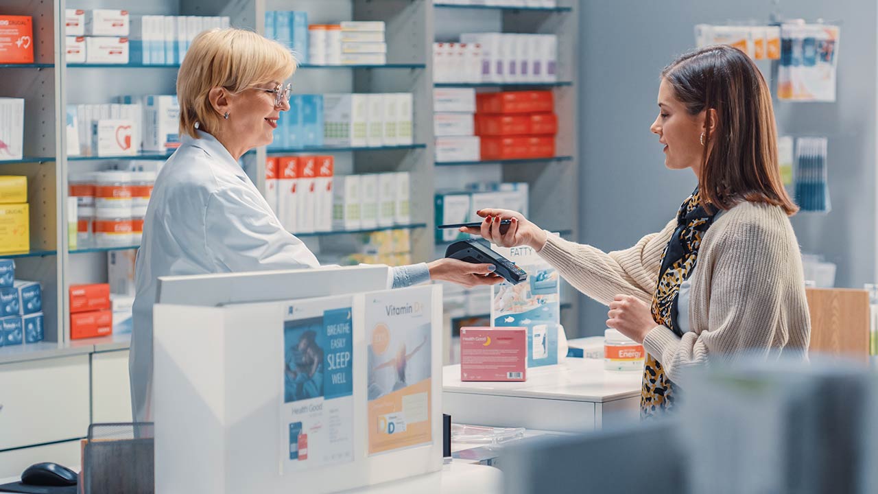 Woman using contactless payment at a pharmacy.