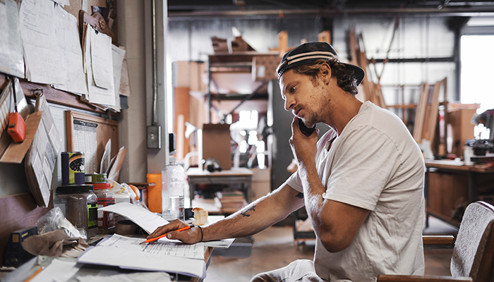 Man on his phone in his workshop