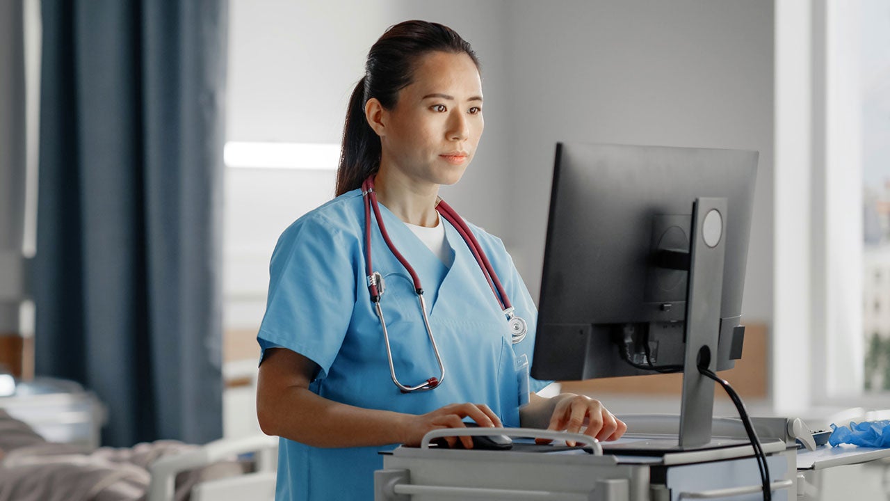 Nurse uses computer checking medical data.