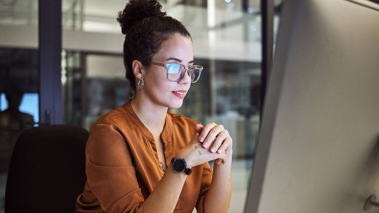Business woman working on a computer in her startup office at night.
