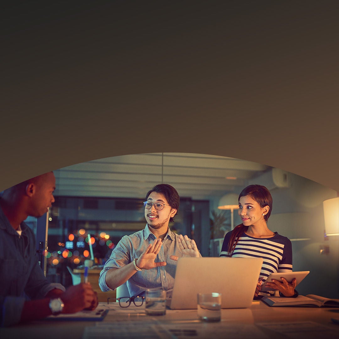 Group of people working around computer monitor