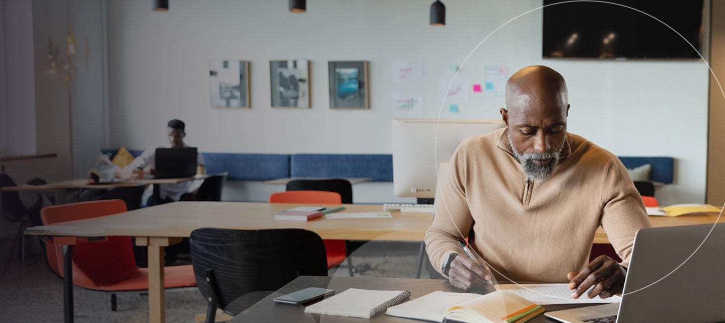 Un homme concentré écrivant à son bureau