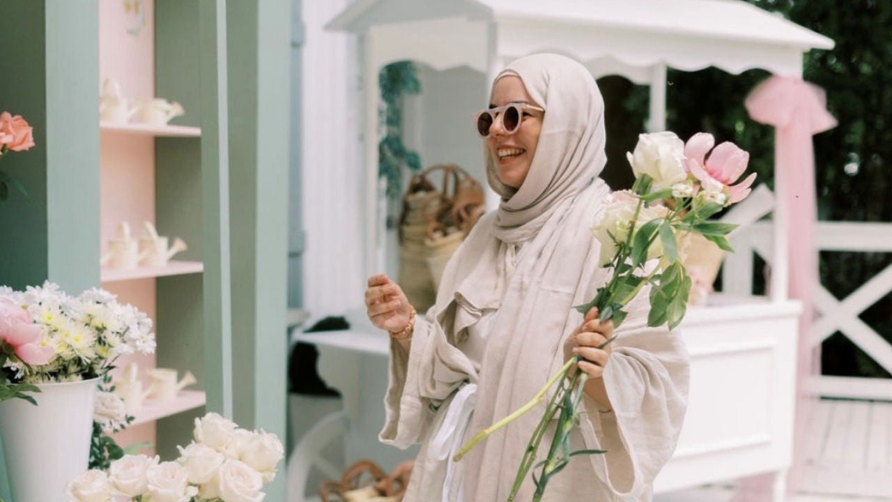 Dana Chehab holds flowers in front of a floral display. 