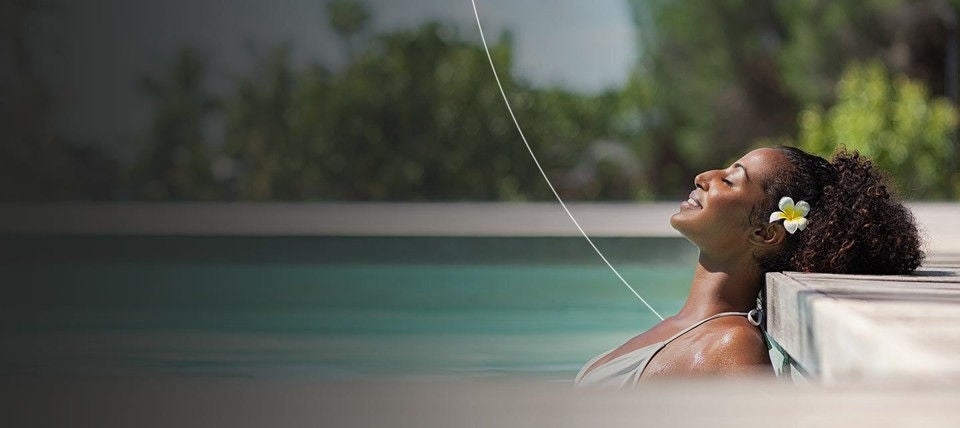 Woman relaxing in luxurious pool.