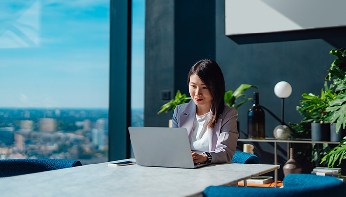 Woman on her laptop in the office with a nice view