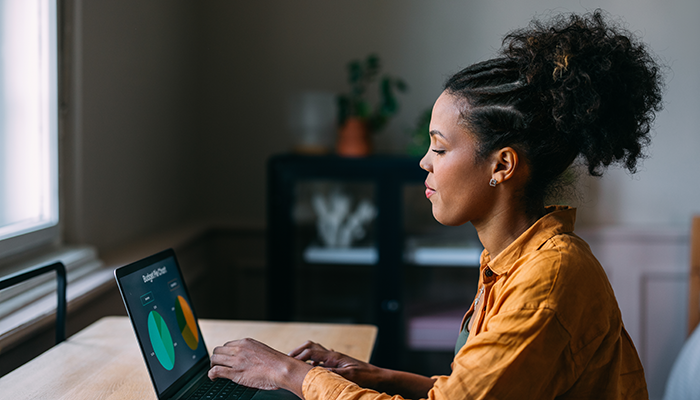 Woman in an orange shirt using her laptop