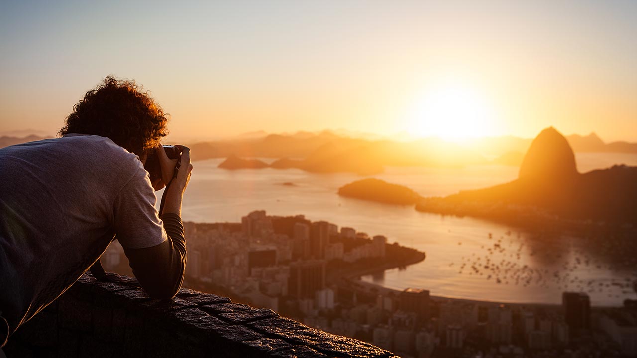 man taking photo of sunset
