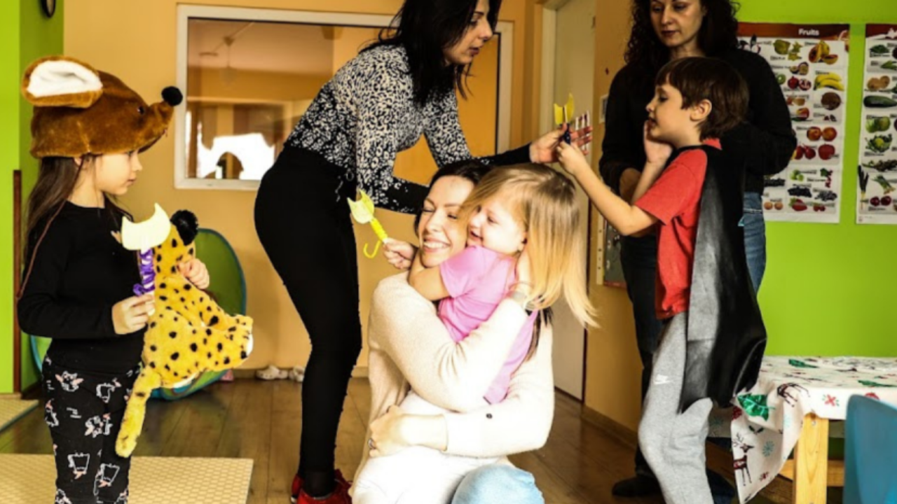 Polina Khlibanovska, who fled Ukraine for Poland, hugs one of her charges at the kindergarten she opened in Warsaw. 