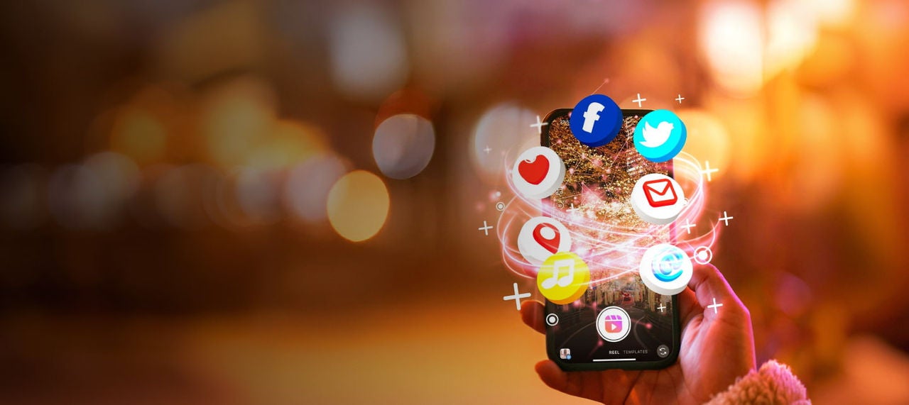 hand holding phone social icons