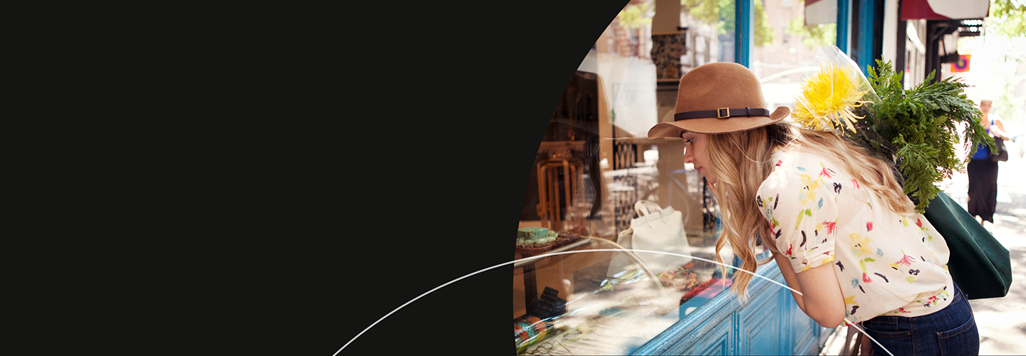 Woman window shopping while carrying flowers