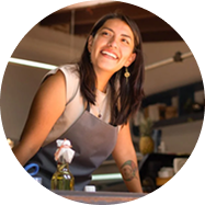woman wearing apron smiling and working in a retail setting