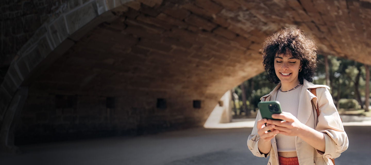 A woman is standing in a tunnel looking at her cell