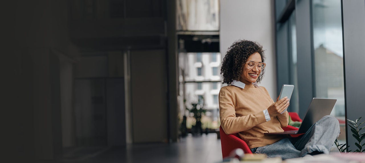 Woman using devices in modern office.