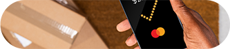 A person is using a smartphone with a credit card shown on the display, representing mobile banking or shopping.