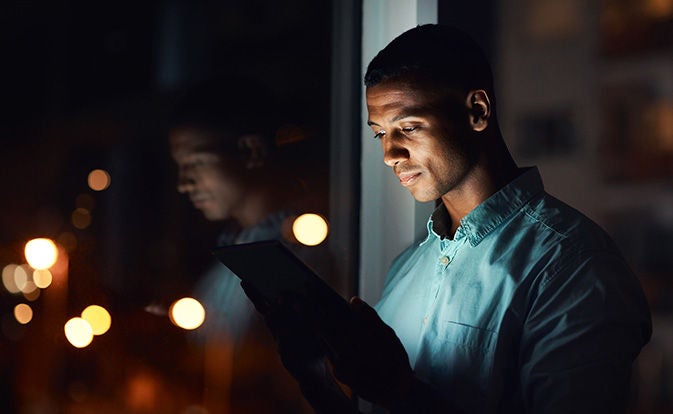 Man using mobile phone next to window.
