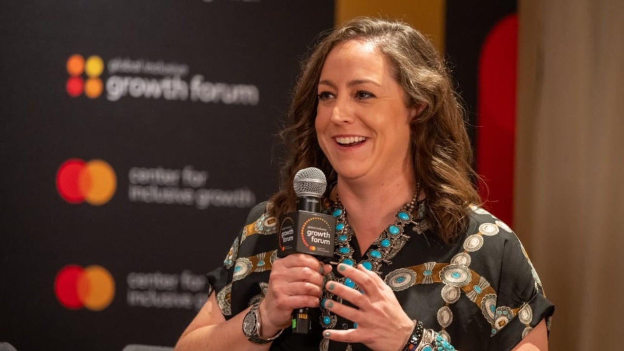 Morgan Buckert at the GIG Forum in Washington DC on stage speaking into the microphone