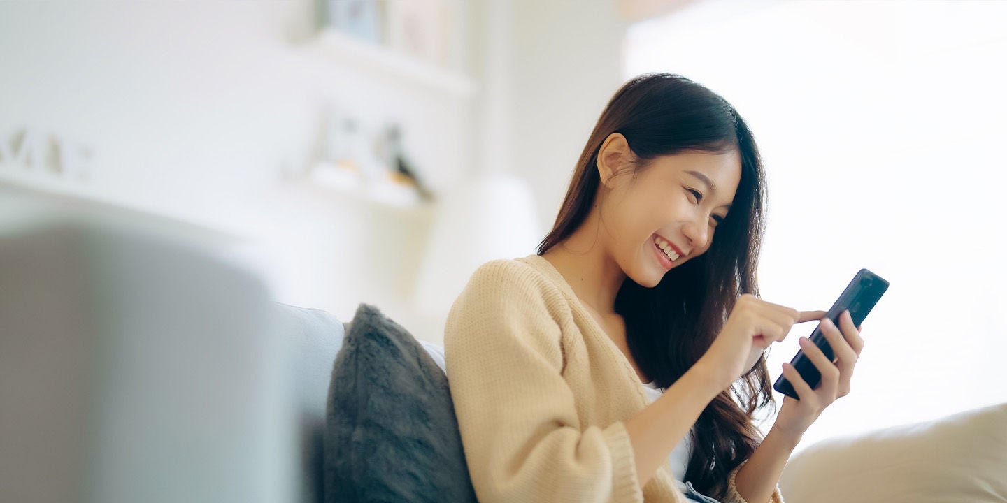 Woman smiling while shopping on her phone