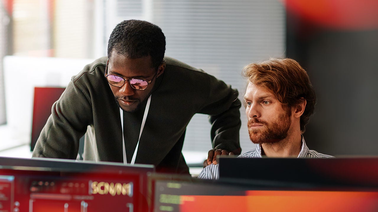 Two coworkers looking over data on computers